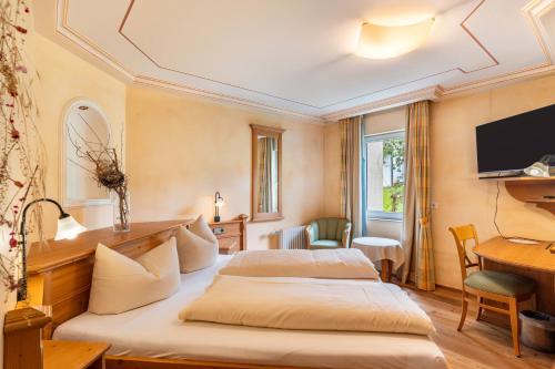 a hotel room with two beds and a desk at Wein- und Klimahotel Bergfriedel in Bühlertal
