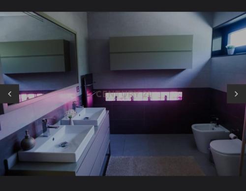a bathroom with two sinks and a toilet at La Perla in Fermentelos