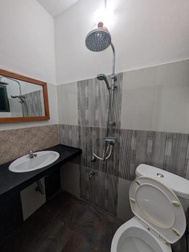 a bathroom with a shower and a toilet and a sink at Sea Breeze Rest in Talalla