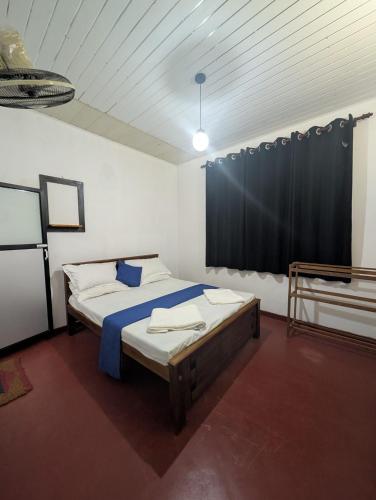 a bedroom with a bed and a black curtain at Sea Breeze Rest in Talalla