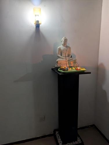 a statue on a table in a room with a light at Sea Breeze Rest in Talalla