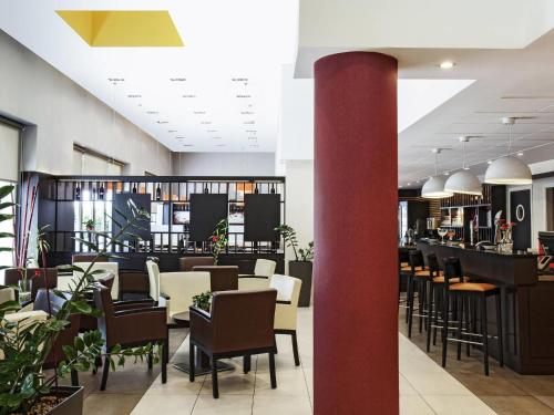 a dining room with chairs and a bar at Ibis Barcelona Mollet in Mollet del Vallès