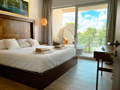 a bedroom with a bed with two towels on it at Stylish Playacar Condo with Balcony & Pool in Playa del Carmen