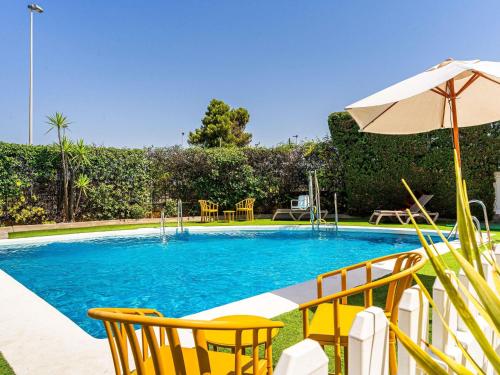 a swimming pool with chairs and an umbrella at Ibis Jerez De La Frontera Cadiz in Jerez de la Frontera
