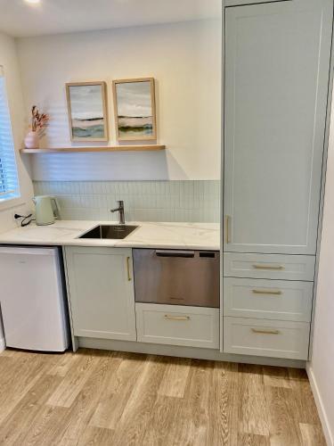 a kitchen with white cabinets and a sink at The Quarters in Turangi