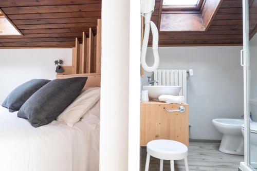 two images of a bedroom with a bed and a bathroom at Hotel Miralago in Misurina