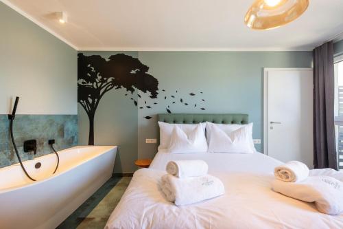 a bedroom with a large bed and a bathtub at WEIDE SUITES Stubaital - Adults Only in Schönberg im Stubaital