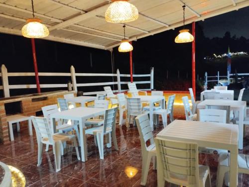 a restaurant with white tables and chairs and lights at El Mirador Hotel Rural in Santa Rosa de Cabal