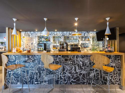 a bar with a wall covered in graffiti at Ibis Bilbao Barakaldo in Barakaldo