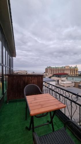a wooden table and a chair on a balcony at Grandview Boutique Hotel in Baku