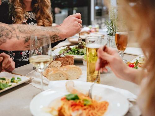 a group of people sitting at a table with food and drinks at Ibis Bilbao Barakaldo in Barakaldo