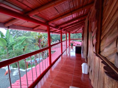 a balcony of a house with a red railing at El Mirador Hotel Rural in Santa Rosa de Cabal