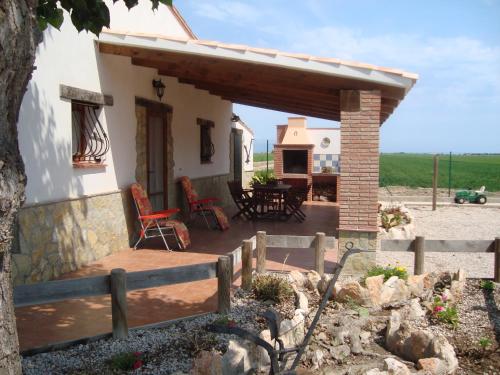 a house with a patio with a table and chairs at Caseta Les Creus in Riumar