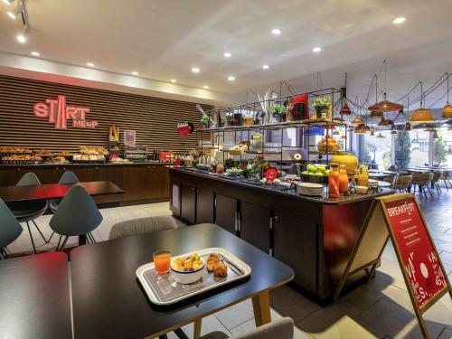 un restaurante con una mesa y una bandeja de comida en Ibis Madrid Calle Alcalá, en Madrid