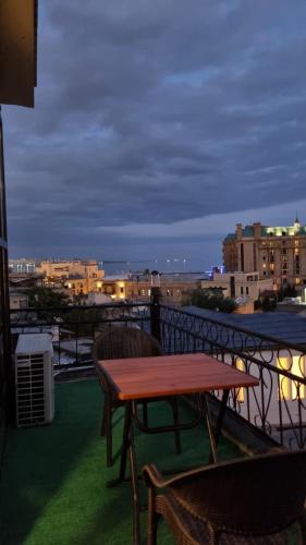 a table and chairs on a balcony at night at Grandview Boutique Hotel in Baku