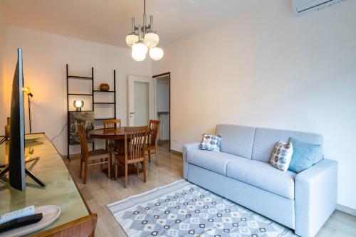 ein Wohnzimmer mit einem blauen Sofa und einem Tisch in der Unterkunft Homing - Prestinari 15 in Mailand