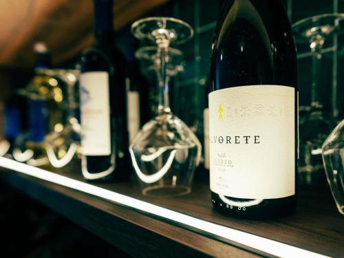 a bottle of wine sitting on a shelf with wine glasses at Ibis Styles Madrid Centro Maravillas in Madrid
