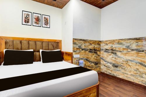 a bedroom with a bed and a stone wall at HOTEL O VIN INN in New Delhi