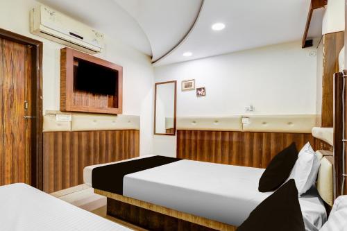 a bedroom with two beds and a tv on the wall at HOTEL O VIN INN in New Delhi