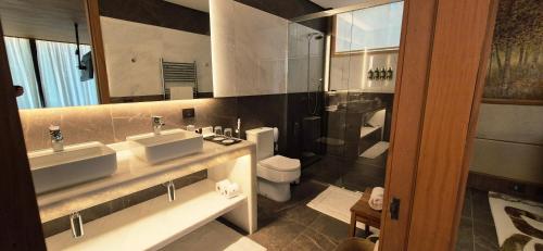 a bathroom with two sinks and a shower at Hotel Toriba in Campos do Jordão