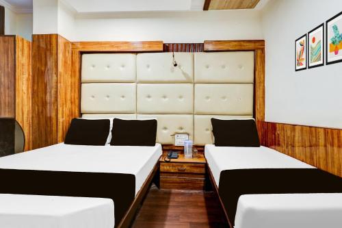 two beds in a room with white and wooden walls at HOTEL O VIN INN in New Delhi