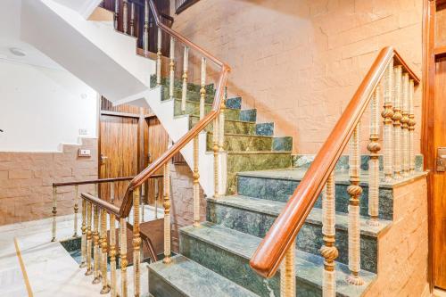a staircase in a home with wooden railings at HOTEL O VIN INN in New Delhi