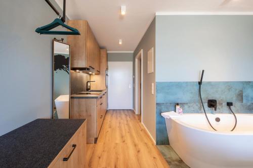 a bathroom with a large white tub and a sink at WEIDE SUITES Stubaital - Adults Only in Schönberg im Stubaital