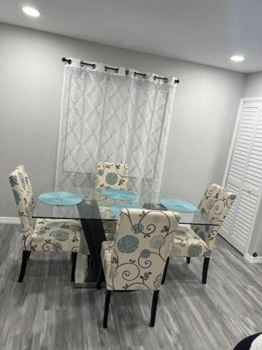 a dining room with a glass table and two chairs at Fully Furnished Home in St Cloud in Saint Cloud