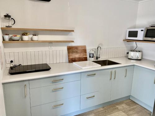 a kitchen with white cabinets and a sink at The Quarters in Turangi