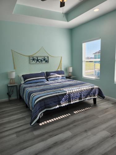 ein Schlafzimmer mit einem großen Bett mit blauen Wänden in der Unterkunft Escape to the beach with pets &kids in Bolivar Peninsula