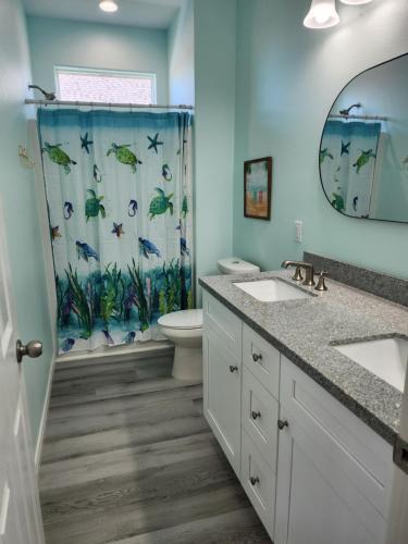 ein Badezimmer mit zwei Waschbecken und einer Dusche in der Unterkunft Escape to the beach with pets &kids in Bolivar Peninsula