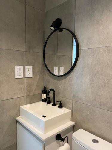 a bathroom with a white sink and a mirror at Monoambiente a estrenar con BALCÓN y DECK in La Plata