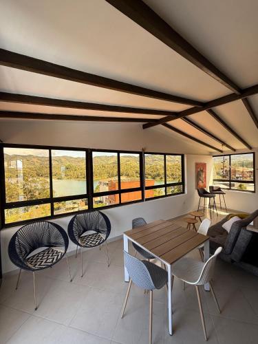 un salon avec une table, des chaises et des fenêtres dans l'établissement Apartamento amoblado Nice view, à Estación El Salto