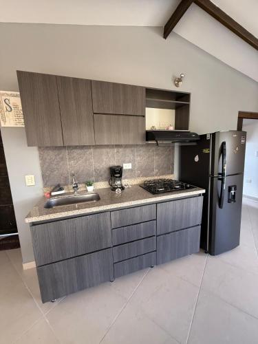 La cuisine est équipée d'un réfrigérateur noir et d'un évier. dans l'établissement Apartamento amoblado Nice view, à Estación El Salto