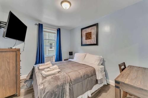 a bedroom with a bed and a flat screen tv at Shortstop Apt 1 All Star Baseball Rentals in Oneonta