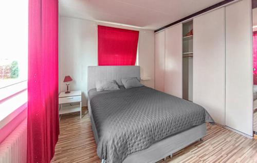 ein Schlafzimmer mit einem Bett und einem roten Vorhang in der Unterkunft Villa i Åstorp in Åstorp