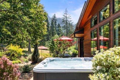 a hot tub in a yard next to a house at Mountain-View Retreat with Hot Tub & Waterfalls in Cascade Locks