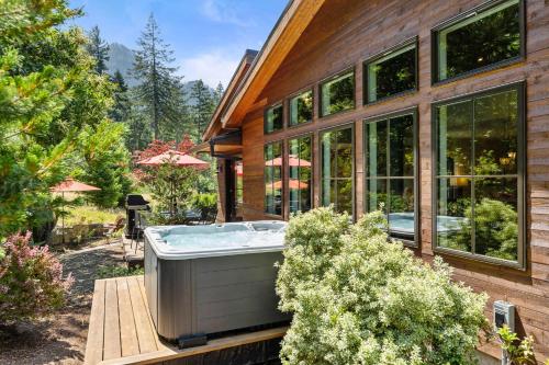 a hot tub on the side of a house at Mountain-View Retreat with Hot Tub & Waterfalls in Cascade Locks