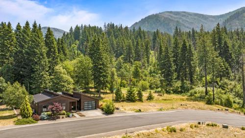 a home in the mountains with a road in front at Mountain-View Retreat with Hot Tub & Waterfalls in Cascade Locks