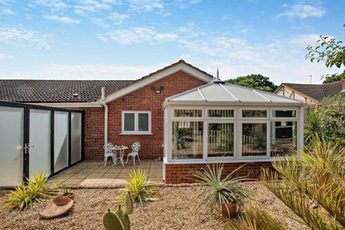 a conservatory with a table and chairs on a patio at The Palms in Brundall