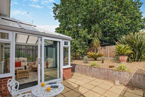 a conservatory with glass doors and a patio at The Palms in Brundall
