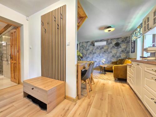 a kitchen and dining room with a table and a living room at Domek pod Świerkami & Jacuzzi in Jelenia Góra