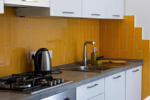 a kitchen with a sink and a stove with orange tiles at Marina - appartamento in centro al mare Ostia in Lido di Ostia