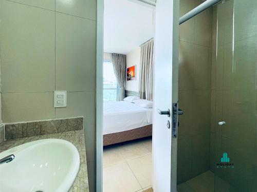 une salle de bain avec un lavabo et une douche et un lit dans l'établissement Reserva Dunnas by Holiday Stays, à Mangabeira