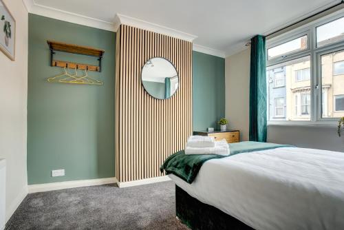 a bedroom with a large bed and a mirror at Station House in Redcar