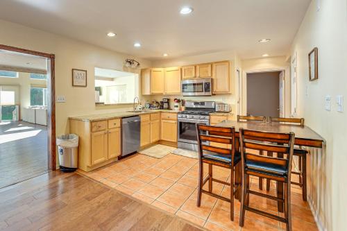 a kitchen with wooden cabinets and a counter with chairs at Hot Tub and Game Room Spacious Whitehall Home! in Whitehall