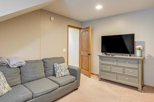 a living room with a gray couch and a flat screen tv at Hot Tub and Game Room Spacious Whitehall Home! in Whitehall