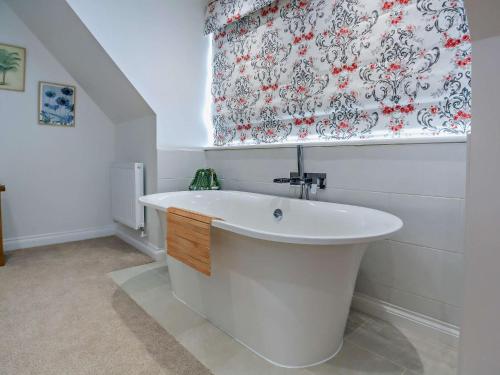 a white bath tub in a bathroom with a curtain at 4 Bed in Saint Asaph 96246 in St Asaph
