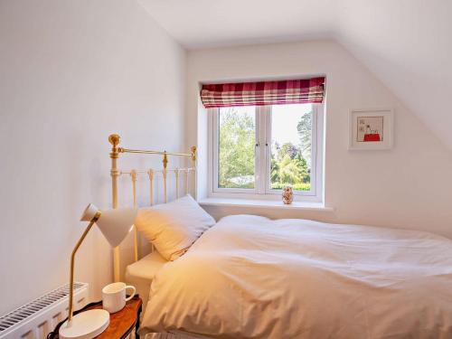 a white bedroom with a bed and a window at 4 Bed in Saint Asaph 96246 in St Asaph