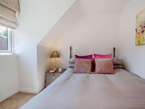 a white bedroom with a bed with two pillows at 4 Bed in Saint Asaph 96246 in St Asaph